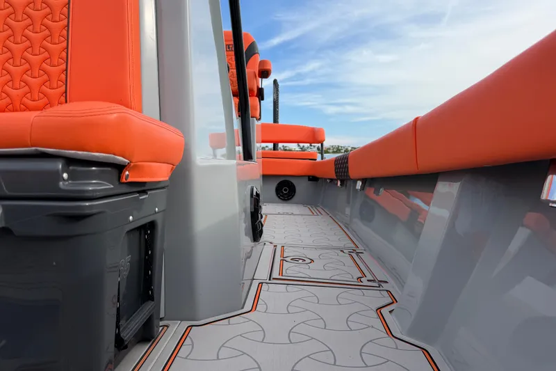 Slide: The Image of 2026 Latitude Tournament Boats 25 interior with orange seating and patterned flooring. - 23
