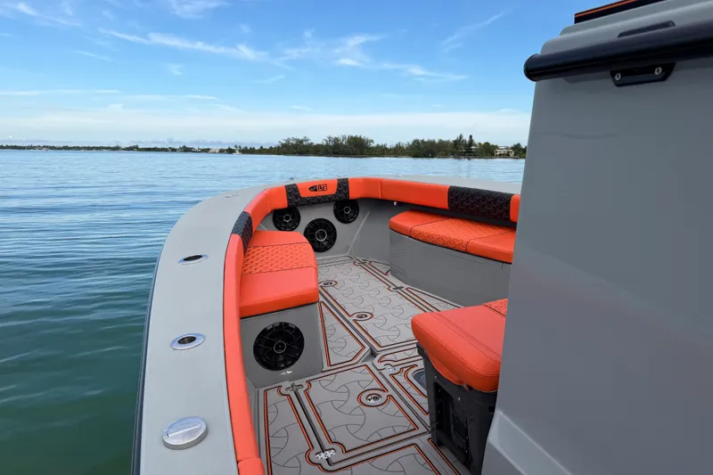 Slide: The Image of 2026 Latitude Tournament Boats 25 with orange seating, on calm waters under a clear sky. - 22