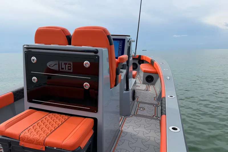 Slide: The Image of 2026 Latitude Tournament Boats 25 with orange seating, sleek design, and advanced navigation system. - 21