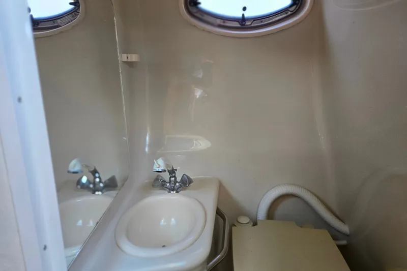 Slide: The Image of 2004 Sea Ray 240 Sundancer bathroom with sink and porthole window. - 20