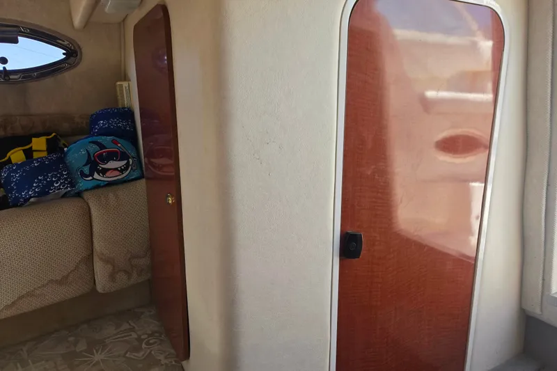 Slide: The Image of Interior of 2004 Sea Ray 240 Sundancer with wooden door and cozy seating area. - 19