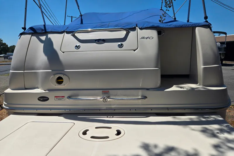 Slide: The Image of 2004 Sea Ray 240 Sundancer boat with blue cover, rear view in sunlight. - 8