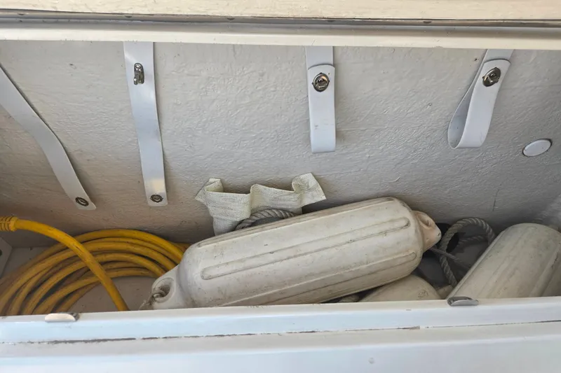 Slide: The Image of Storage compartment of 2004 Sea Ray 240 Sundancer with fenders and yellow cable. - 9