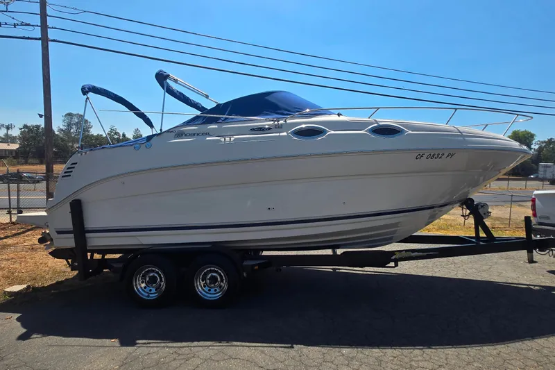 Slide: The Image of 2004 Sea Ray 240 Sundancer boat on trailer, parked outdoors under clear sky. - 6