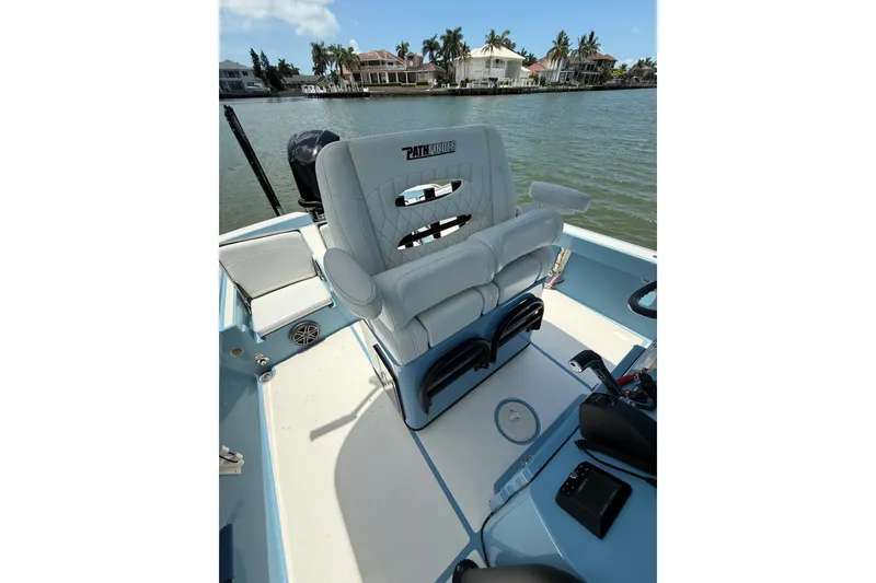 Slide: The Image of 2021 Pathfinder 2600 TRS boat interior with luxurious seating, on a scenic waterfront. - 15
