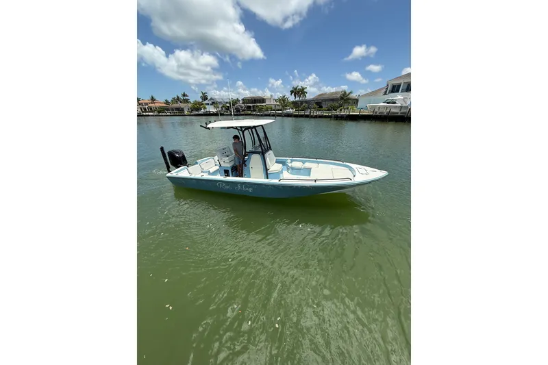 The Image of 2021 Pathfinder 2600 TRS boat on calm water under a clear blue sky. - 1
