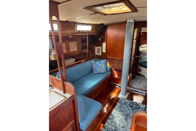 Slide: The Image of Interior of a 1987 Tartan 40 sailboat with blue seating and wooden finishes. - 16