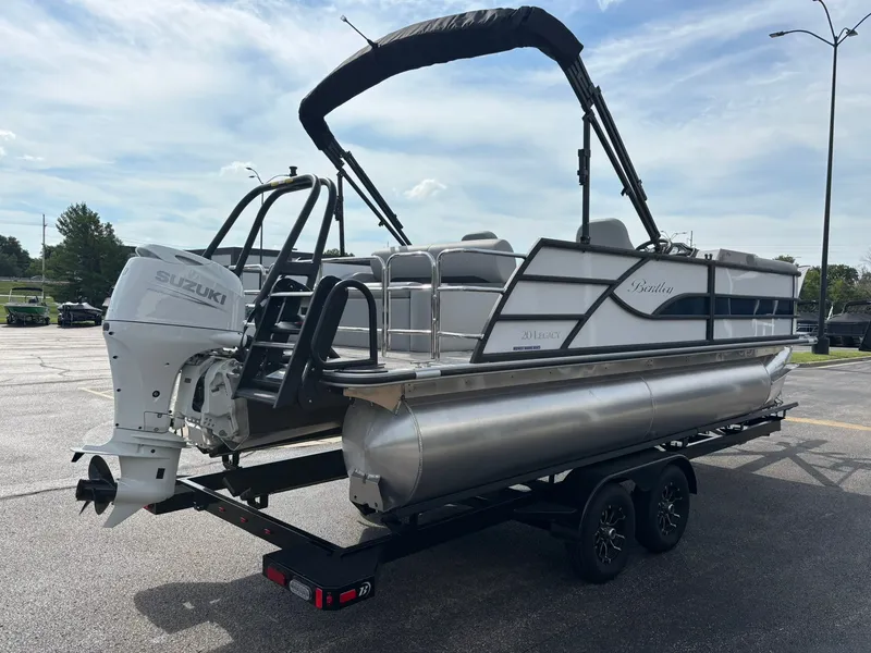 Slide: The Image of A 2027 Bentley Pontoons 200 Legacy Swingback on a trailer. It features a Suzuki outboard motor. - 12
