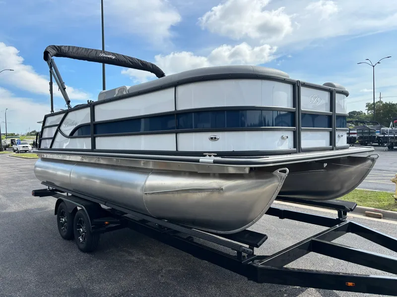 Slide: The Image of A 2027 Bentley Pontoons 200 Legacy Swingback on a trailer. The sky is partly cloudy. - 10
