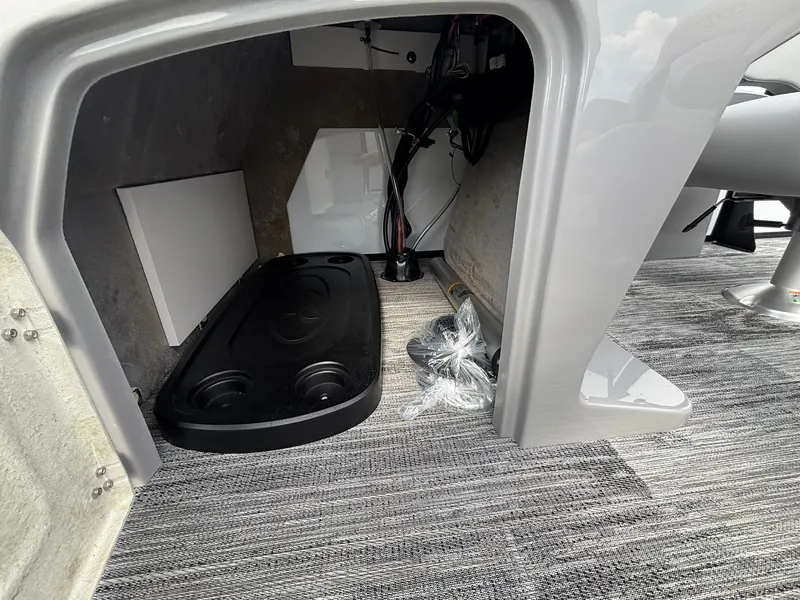 Slide: The Image of The interior of a 2027 Bentley Pontoons 200 Legacy Swingback shows storage space and carpeted flooring. - 17