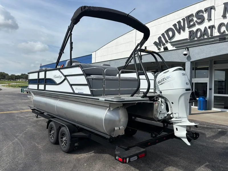 Slide: The Image of A 2027 Bentley Pontoons 200 Legacy Swingback on a trailer outside a boathouse. - 4