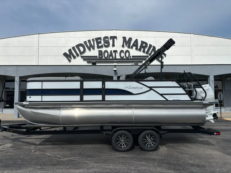 The Image of A 2027 Bentley Pontoons 200 Legacy Swingback on a trailer in front of a boat dealership. - 1