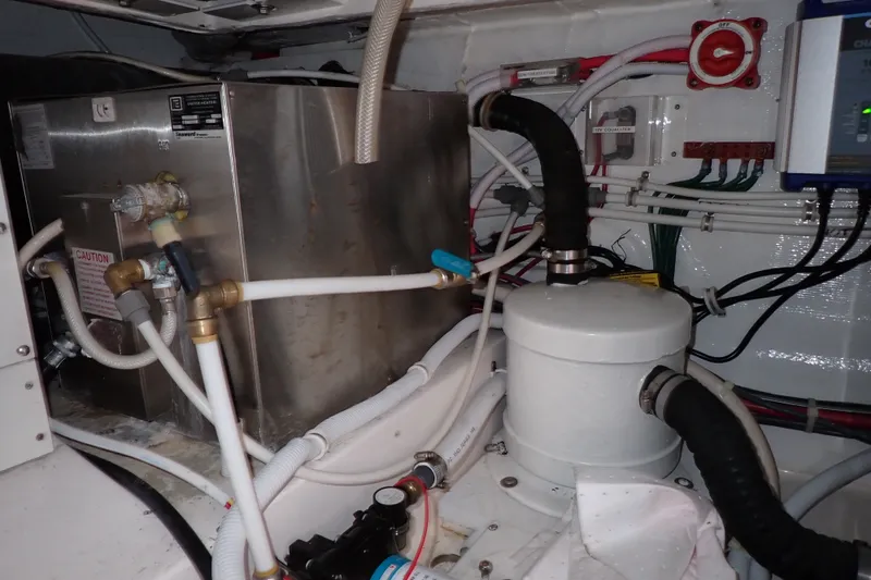 Slide: The Image of Engine room of a 2005 Bertram 390 yacht, featuring plumbing and electrical systems. - 134