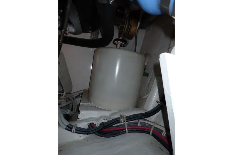 Slide: The Image of Engine compartment of a 2005 Bertram 390 boat, featuring hoses and wiring. - 138