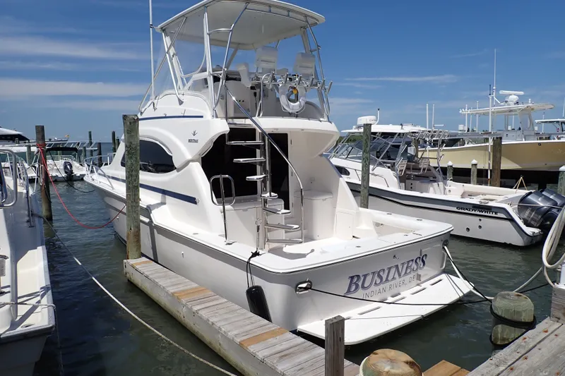 Slide: The Image of 2005 Bertram 390 yacht docked at marina, featuring sleek design and spacious deck. - 5