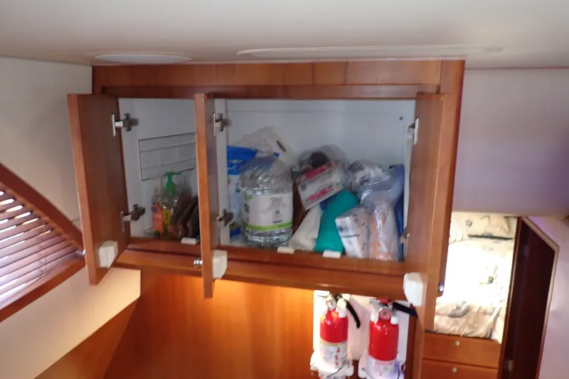 Slide: The Image of Open cabinet on 2005 Bertram 390 yacht, storing supplies and fire extinguishers. - 59