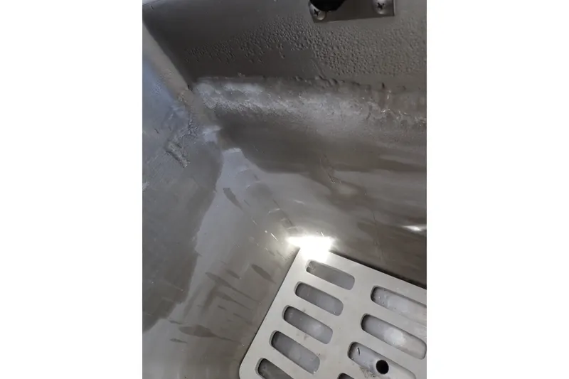 Slide: The Image of Interior view of a 2005 Bertram 390 boat, featuring a metal surface and drainage area. - 120