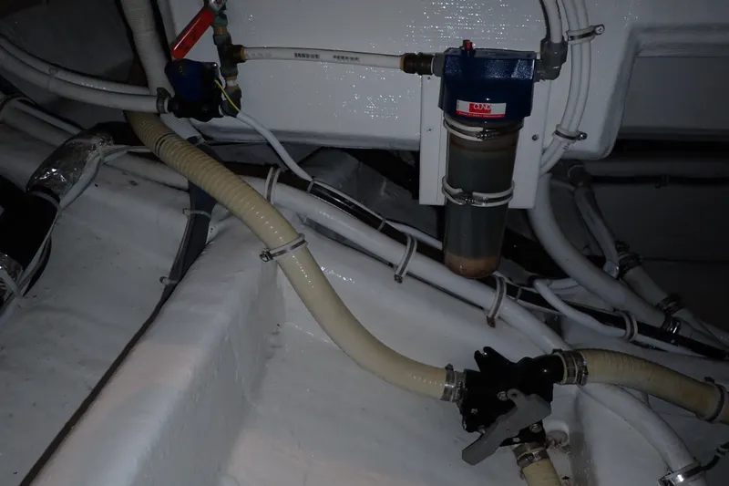 Slide: The Image of Engine room of 2005 Bertram 390 boat, featuring hoses and a fuel filter system. - 106