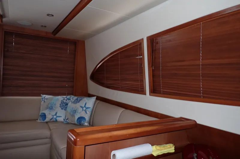 Slide: The Image of Interior of a 2005 Bertram 390 yacht with wooden blinds and nautical-themed cushions. - 80