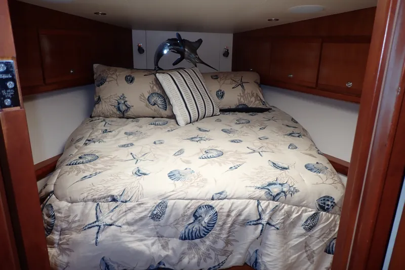 Slide: The Image of Cozy cabin bedroom in 2005 Bertram 390 yacht with nautical-themed bedding. - 82
