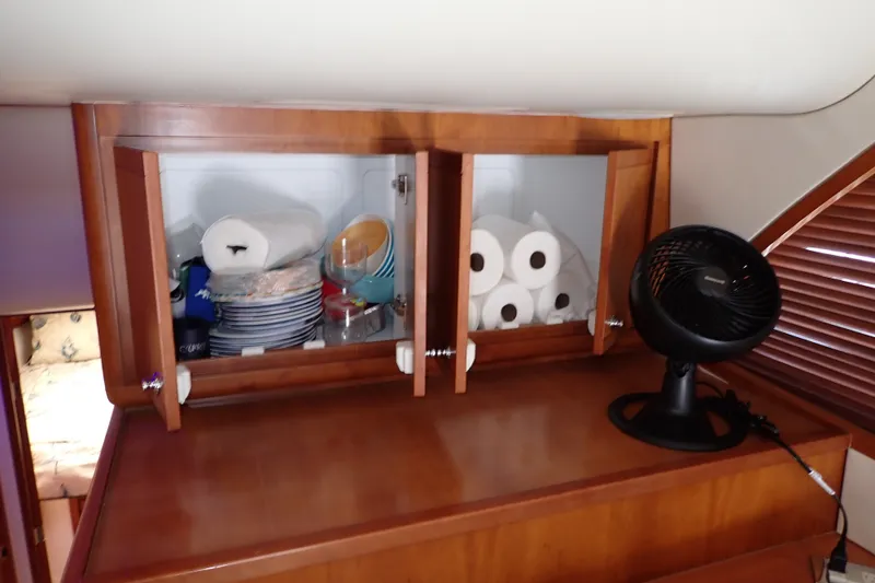 Slide: The Image of Cabinet with dishes and fan inside 2005 Bertram 390 yacht interior. - 67