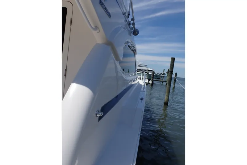 Slide: The Image of Side view of a 2005 Bertram 390 yacht docked by the water. - 25