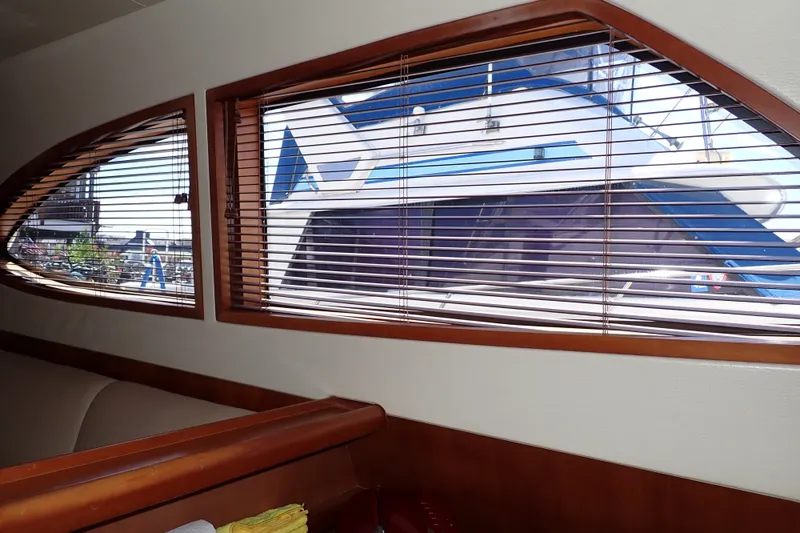 Slide: The Image of Interior view of a 2005 Bertram 390 yacht with wooden blinds and marina outside. - 61