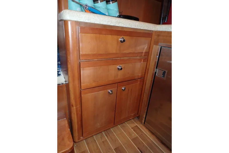 Slide: The Image of Wooden cabinetry in a 2005 Bertram 390 yacht interior, featuring drawers and a countertop. - 52