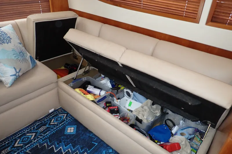 Slide: The Image of 2005 Bertram 390 yacht interior with open storage under beige seating. - 69