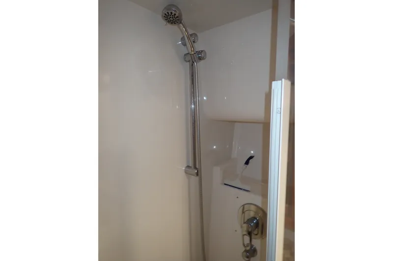 Slide: The Image of Shower area in 2005 Bertram 390 boat, featuring chrome fixtures and white walls. - 99