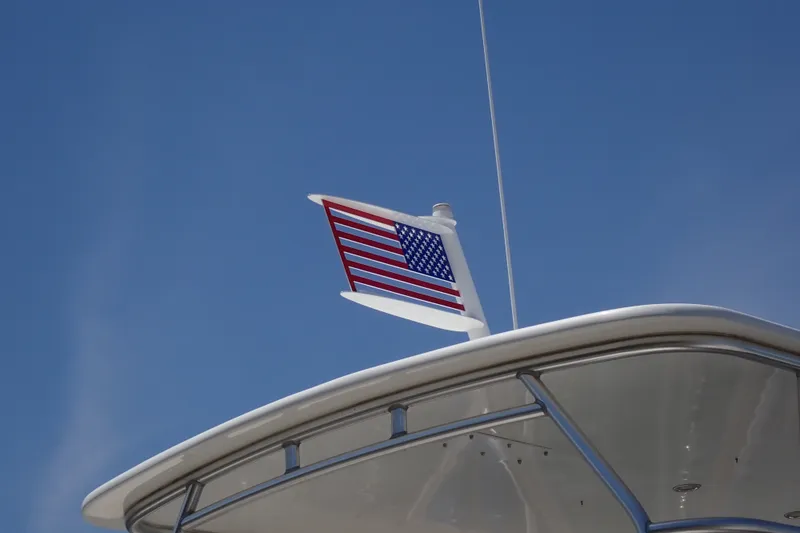 Slide: The Image of American flag on 2005 Bertram 390 yacht against clear blue sky. - 32