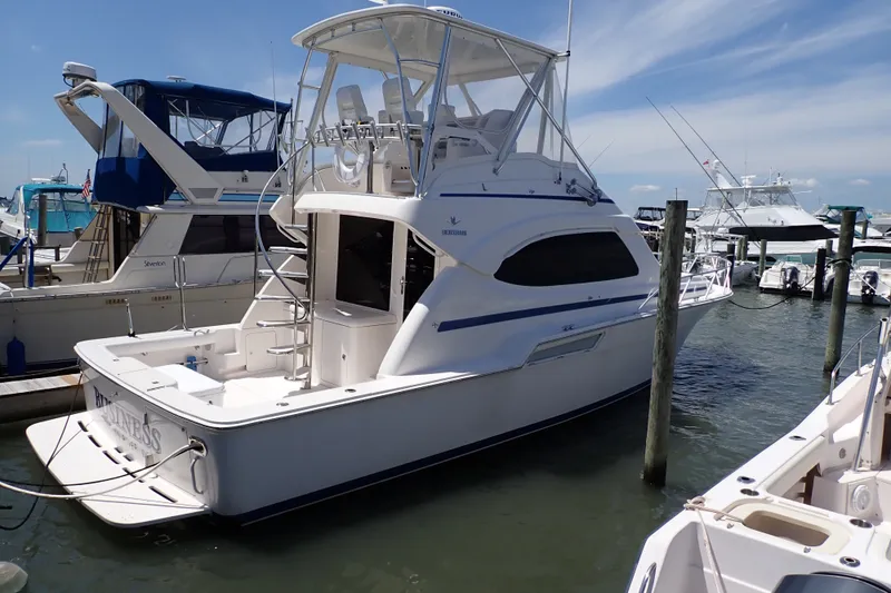The Image of 2005 Bertram 390 yacht docked at marina under clear blue sky. - 0