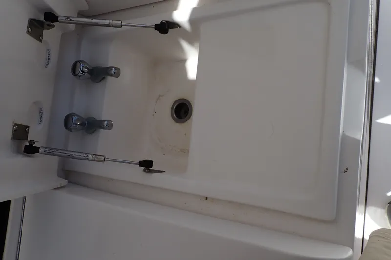Slide: The Image of 2005 Bertram 390 boat sink with dual faucets and drain. - 119