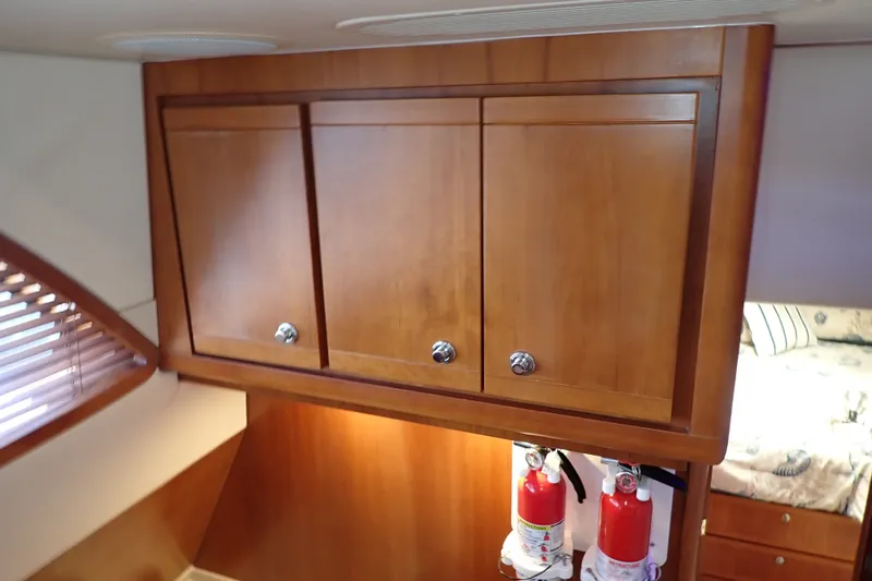 Slide: The Image of Wooden cabinets and fire extinguishers inside a 2005 Bertram 390 yacht interior. - 58