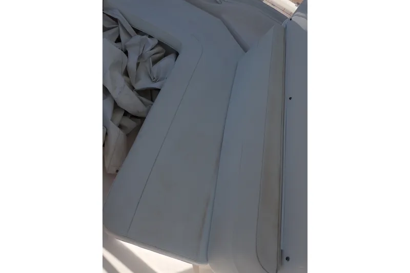 Slide: The Image of Interior seating of a 2005 Bertram 390 boat, featuring light upholstery and folded fabric. - 37