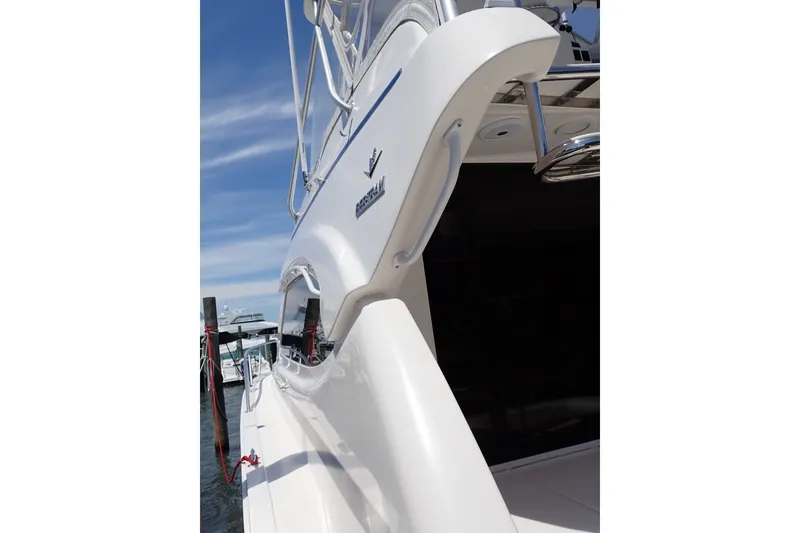 Slide: The Image of 2005 Bertram 390 yacht docked, showcasing sleek white exterior and modern design. - 26