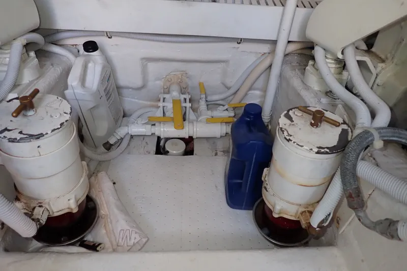 Slide: The Image of Engine compartment of a 2005 Bertram 390 boat with filters and fluid containers. - 124