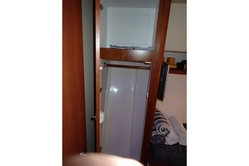 Slide: The Image of Interior of a 2005 Bertram 390 yacht featuring a compact shower area. - 95