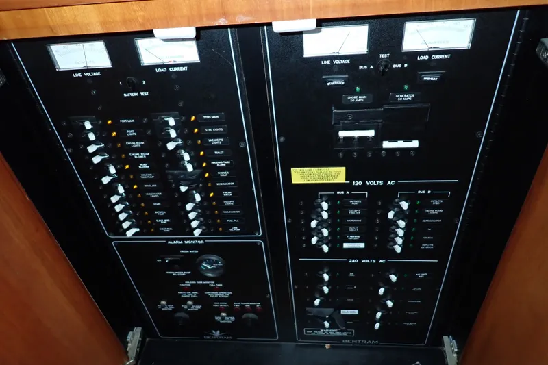 Slide: The Image of Electrical control panel of a 2005 Bertram 390 yacht, featuring various switches and meters. - 75