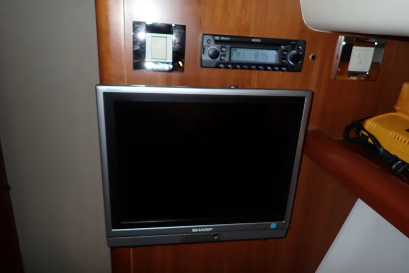 Slide: The Image of Entertainment system in a 2005 Bertram 390 yacht, featuring a Sharp TV and stereo. - 93