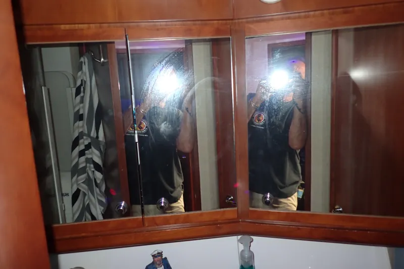 Slide: The Image of Reflection in a wooden cabinet mirror on a 2005 Bertram 390 boat. - 100