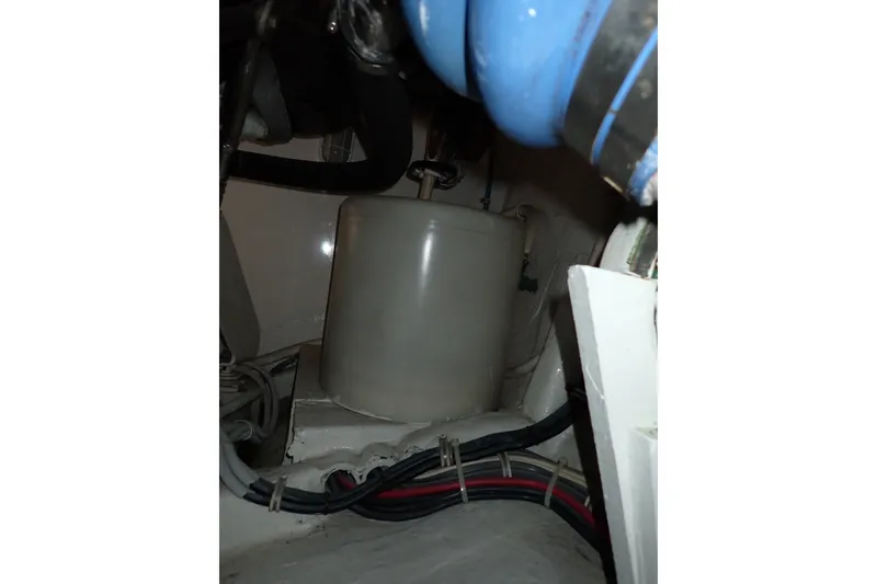 Slide: The Image of Engine compartment of a 2005 Bertram 390 boat, featuring cables and a cylindrical component. - 137