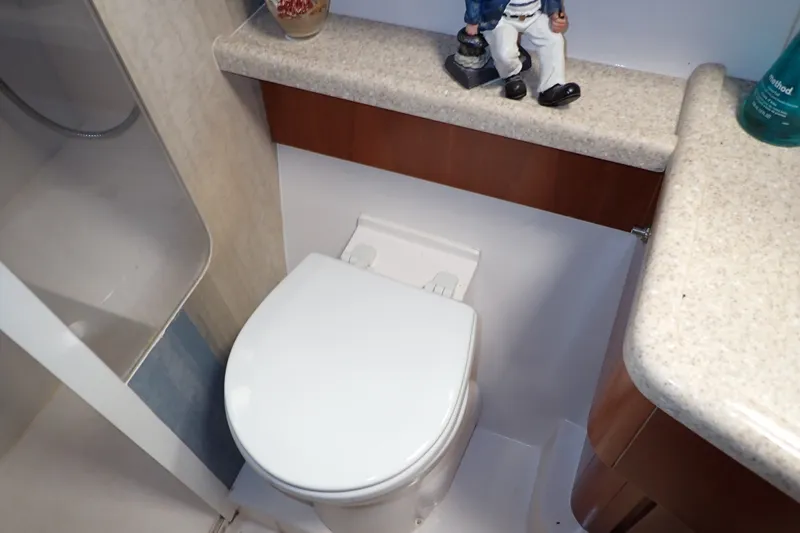 Slide: The Image of Bathroom interior of a 2005 Bertram 390 yacht, featuring a compact toilet and countertop. - 97