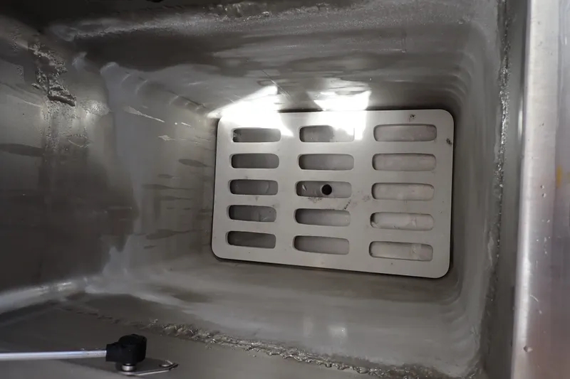 Slide: The Image of Interior of a 2005 Bertram 390 cooler compartment with metal grate and drain. - 121