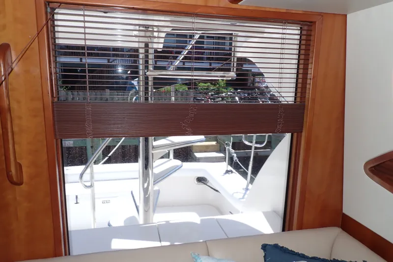 Slide: The Image of Interior view of a 2005 Bertram 390 yacht, featuring a window with blinds. - 65