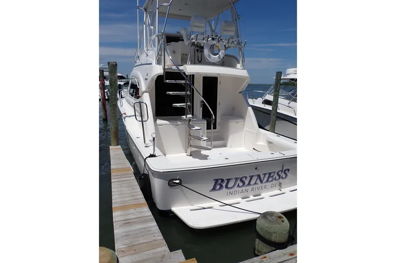 Slide: The Image of 2005 Bertram 390 yacht docked, featuring "Business" name, Indian River, DE. - 3