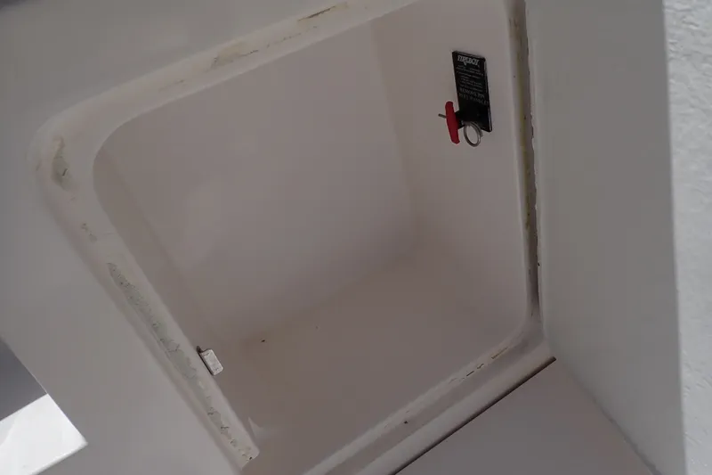 Slide: The Image of Storage compartment on a 2005 Bertram 390 boat, featuring a safety pin and label. - 118