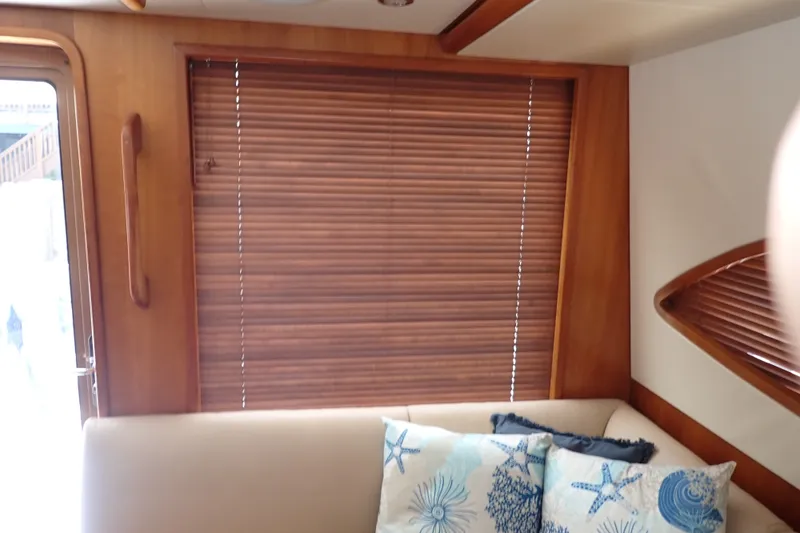 Slide: The Image of Interior of 2005 Bertram 390 yacht with wooden blinds and nautical-themed cushions. - 63
