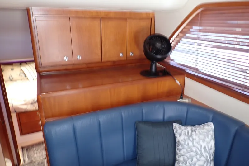 Slide: The Image of Interior of 2005 Bertram 390 yacht with wooden cabinets and blue seating. - 66