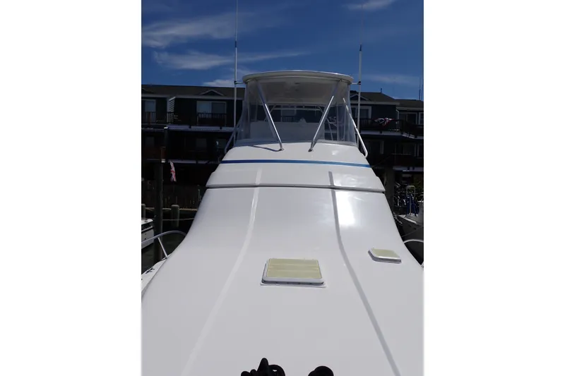 Slide: The Image of 2005 Bertram 390 yacht with sleek white deck and clear blue sky background. - 31